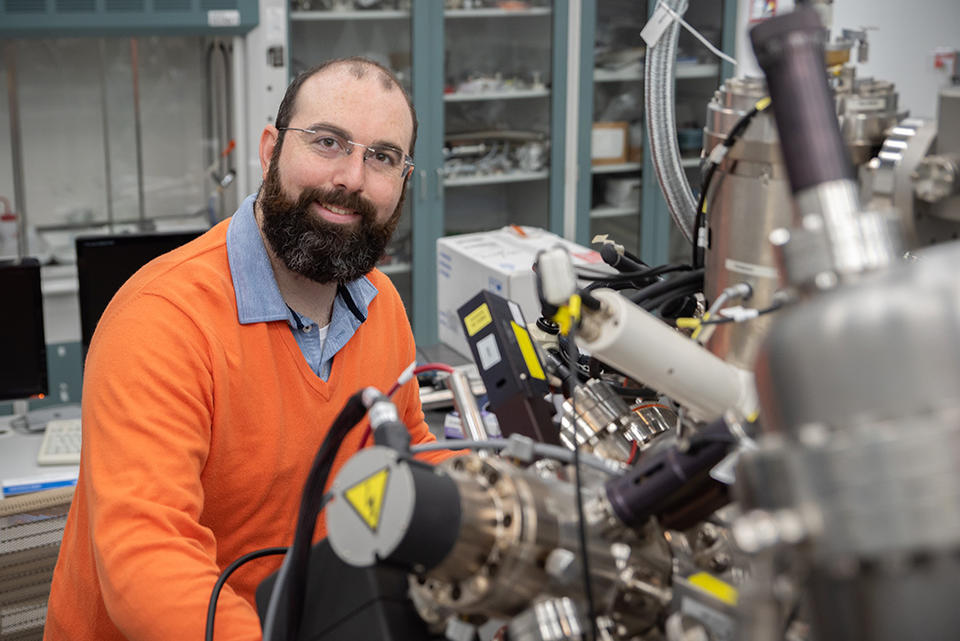 Trey Diulus is standing in a laboratory with a large, complex scientific instrument in front.